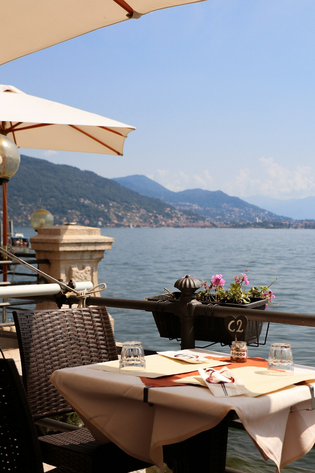 Elegant restaurant terrace set for dinner overlooking a lake